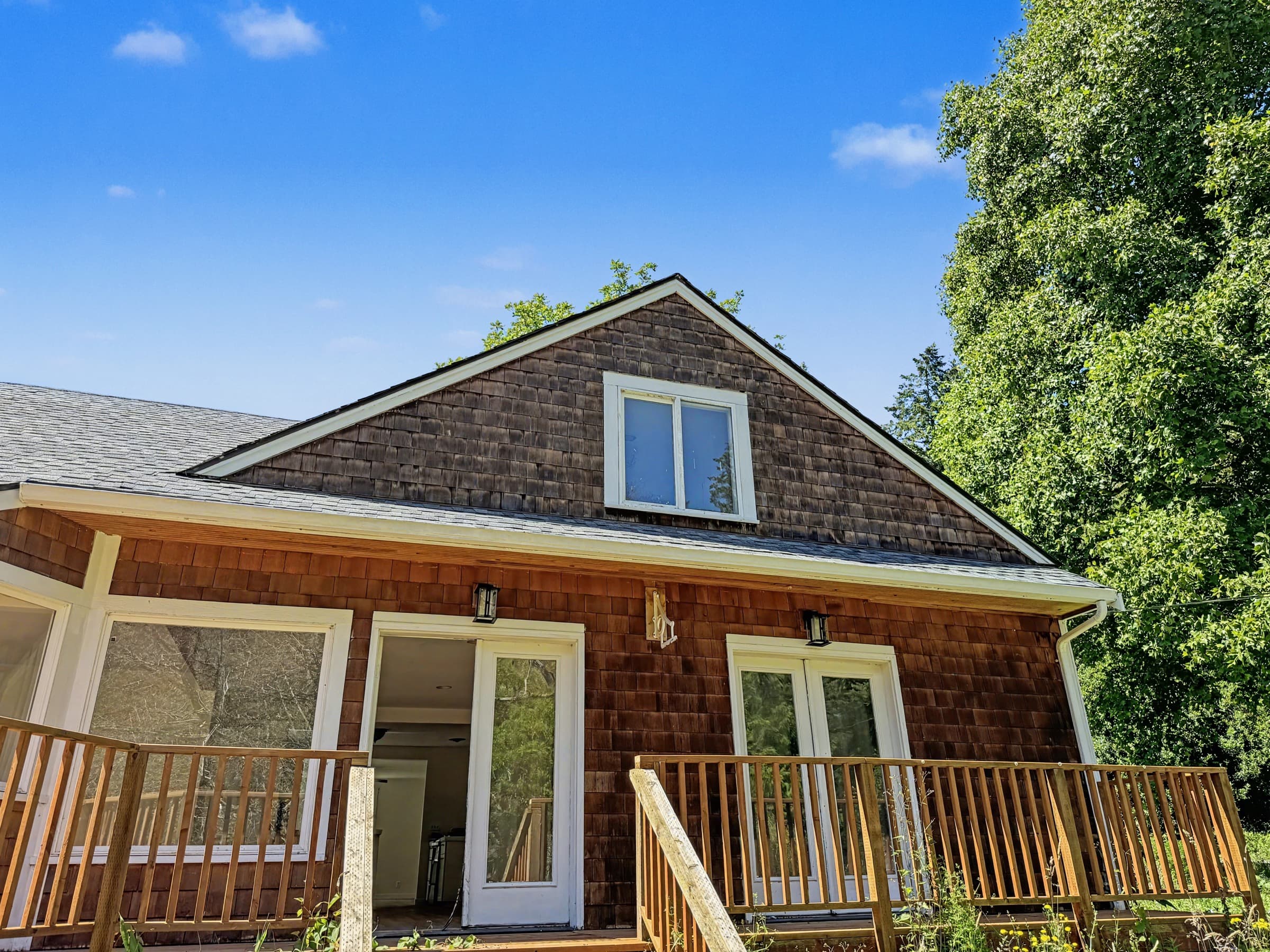 Cedar-shake farmhouse front with covered porch and double doors