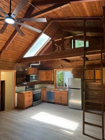 Open-concept kitchen with vaulted wood ceiling and loft