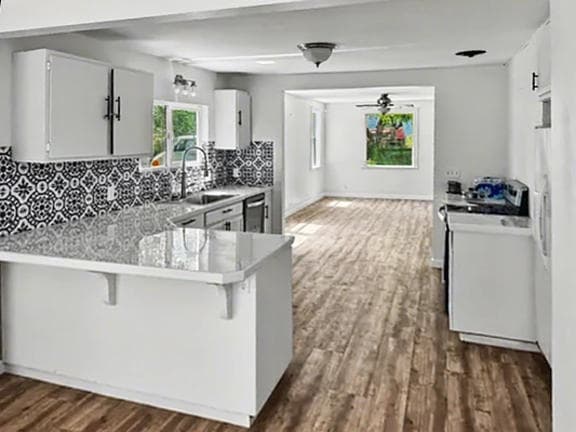 Renovated open kitchen with patterned tile backsplash and white cabinets