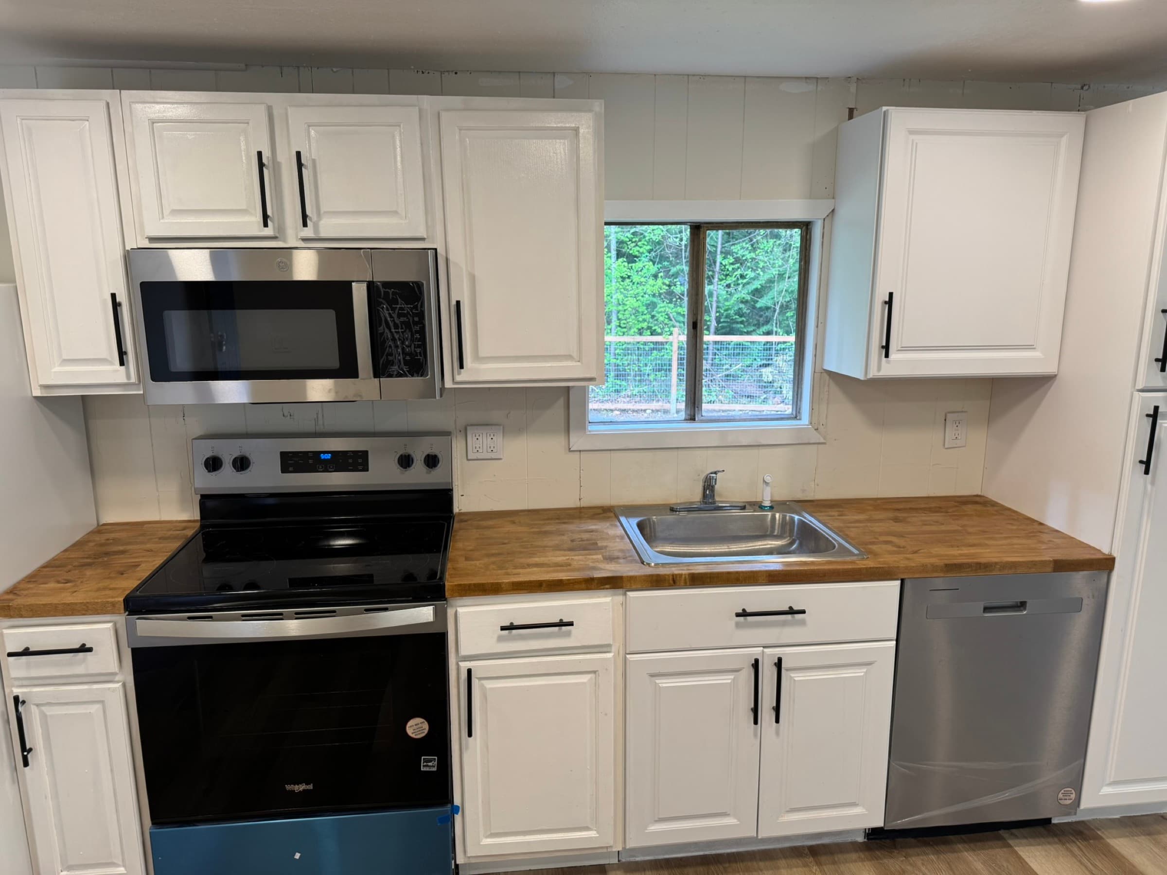 Renovated kitchen with white cabinets and butcher block counters